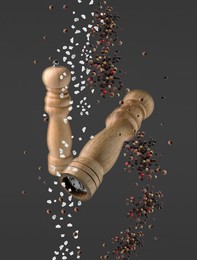 Image of Salt and pepper mills in air on dark grey background