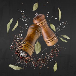 Image of Salt and pepper mills in air on dark grey background