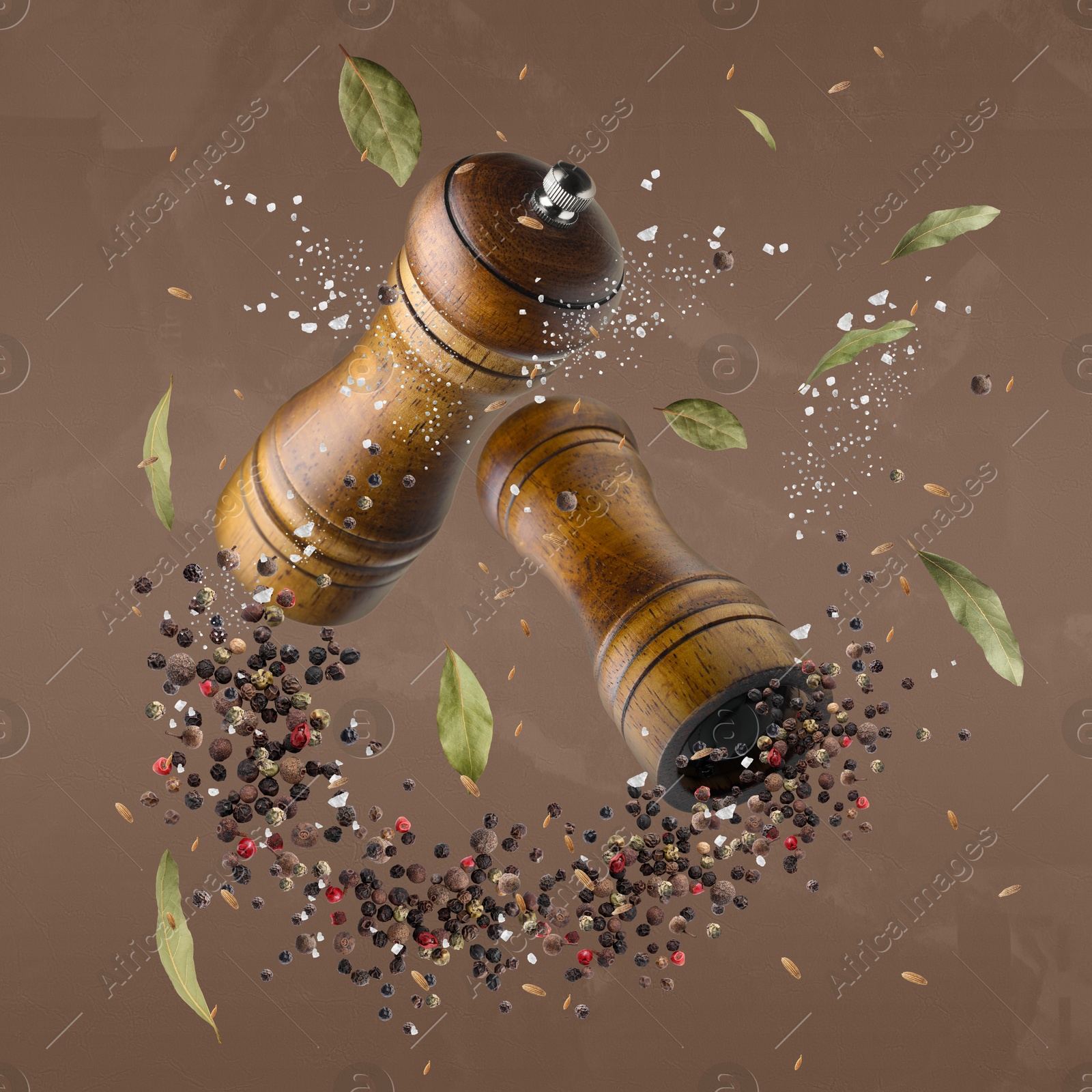 Image of Salt and pepper mills in air on pale brown background