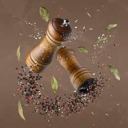 Image of Salt and pepper mills in air on pale brown background