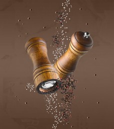 Image of Salt and pepper mills in air on pale brown background