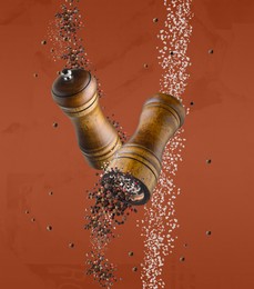 Image of Salt and pepper mills in air on dark orange background