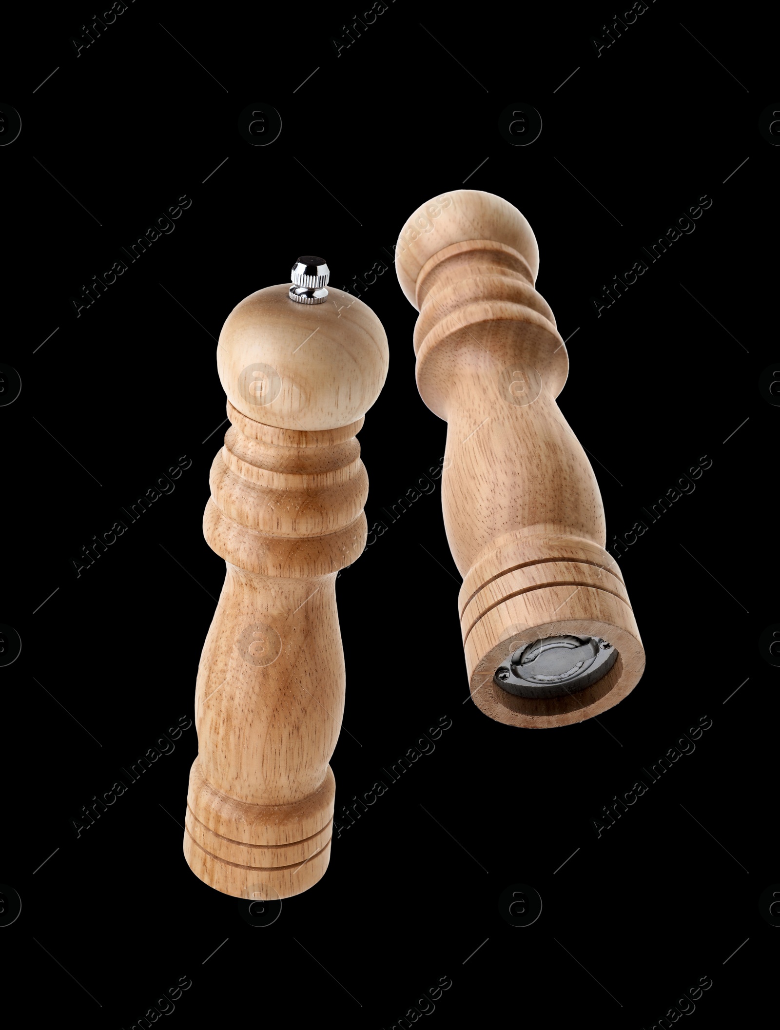 Image of Salt and pepper mills in air on black background