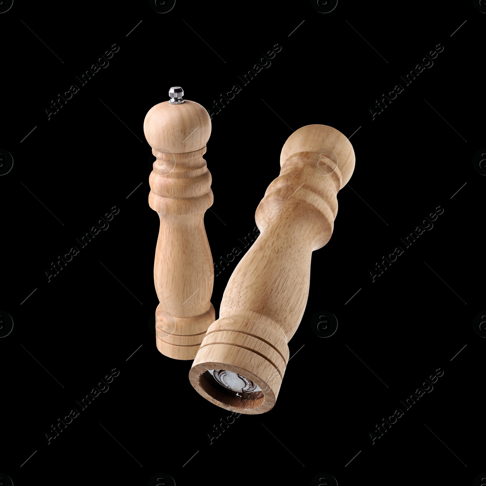 Image of Salt and pepper mills in air on black background