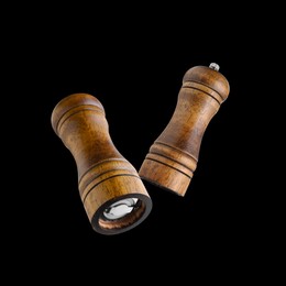 Image of Salt and pepper mills in air on black background