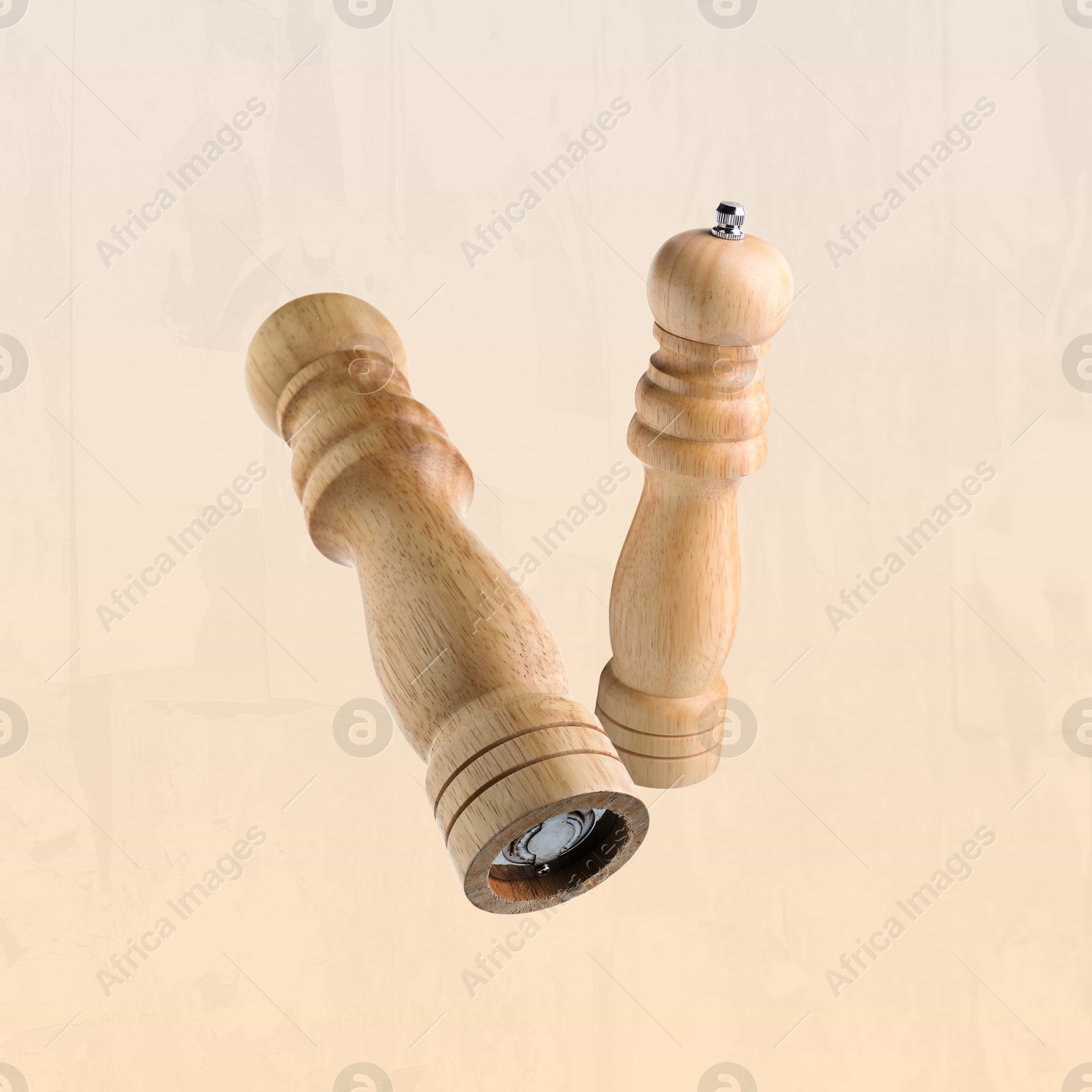 Image of Salt and pepper mills in air on dark beige background