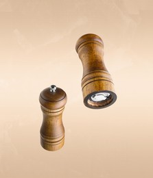 Image of Salt and pepper mills in air on dark beige background