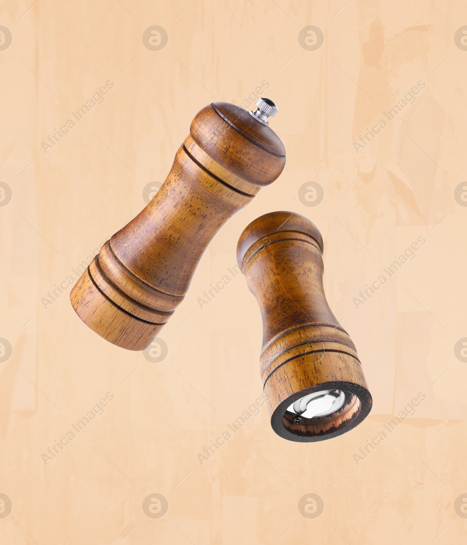 Image of Salt and pepper mills in air on dark beige background