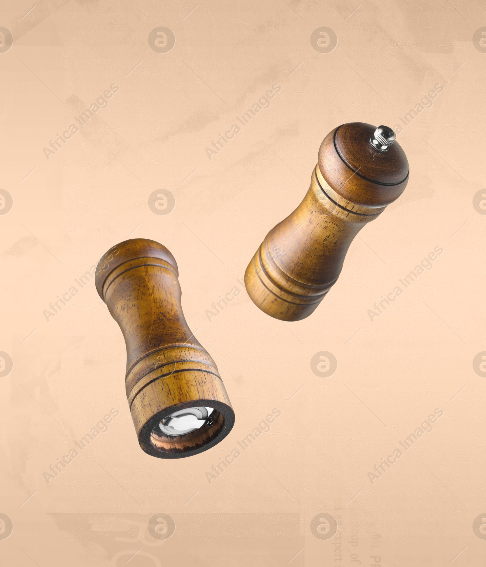 Image of Salt and pepper mills in air on dark beige background