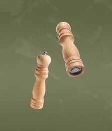 Salt and pepper mills in air on olive color background