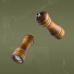 Salt and pepper mills in air on olive color background