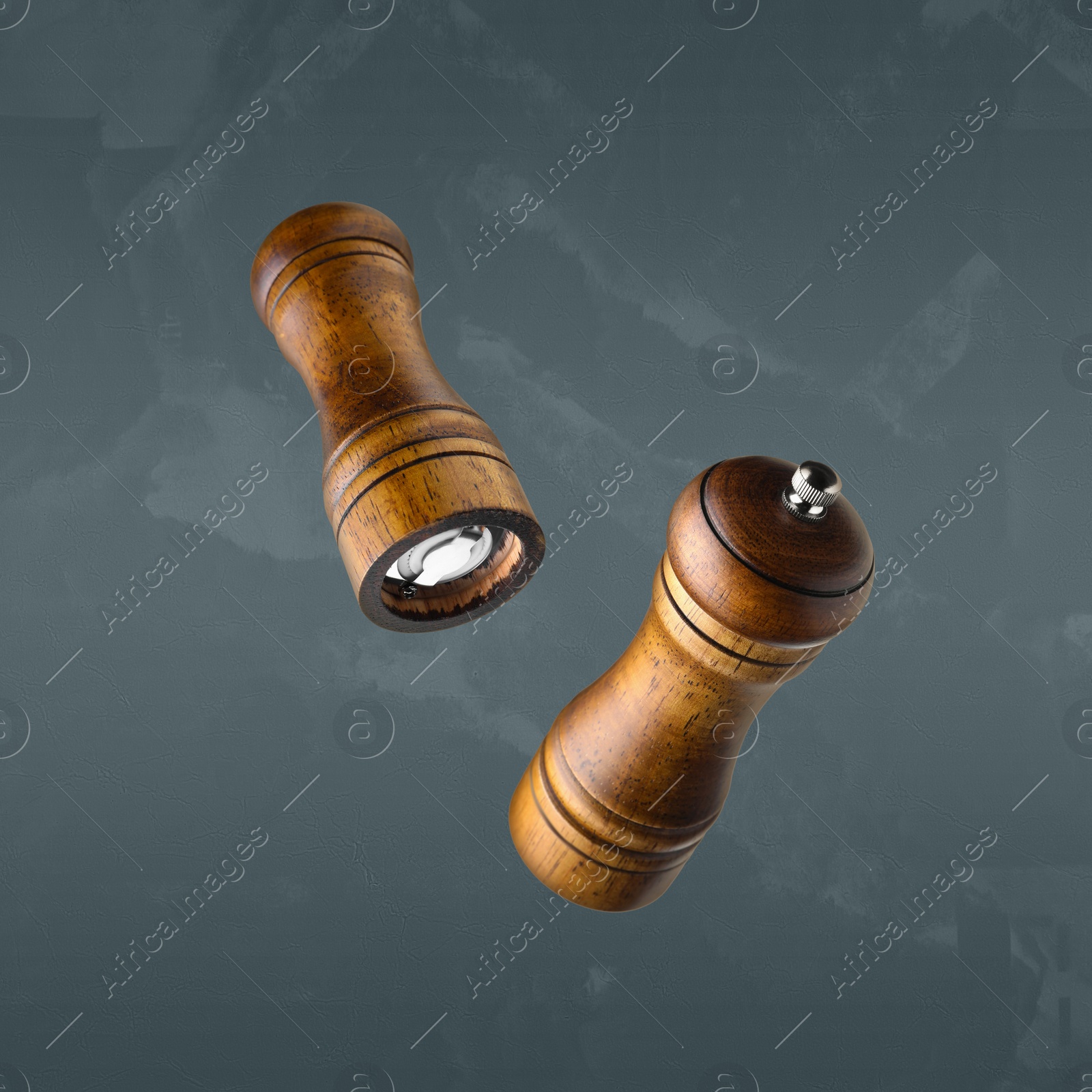 Image of Salt and pepper mills in air on grey background