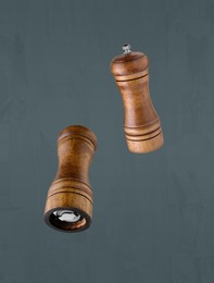 Image of Salt and pepper mills in air on grey background