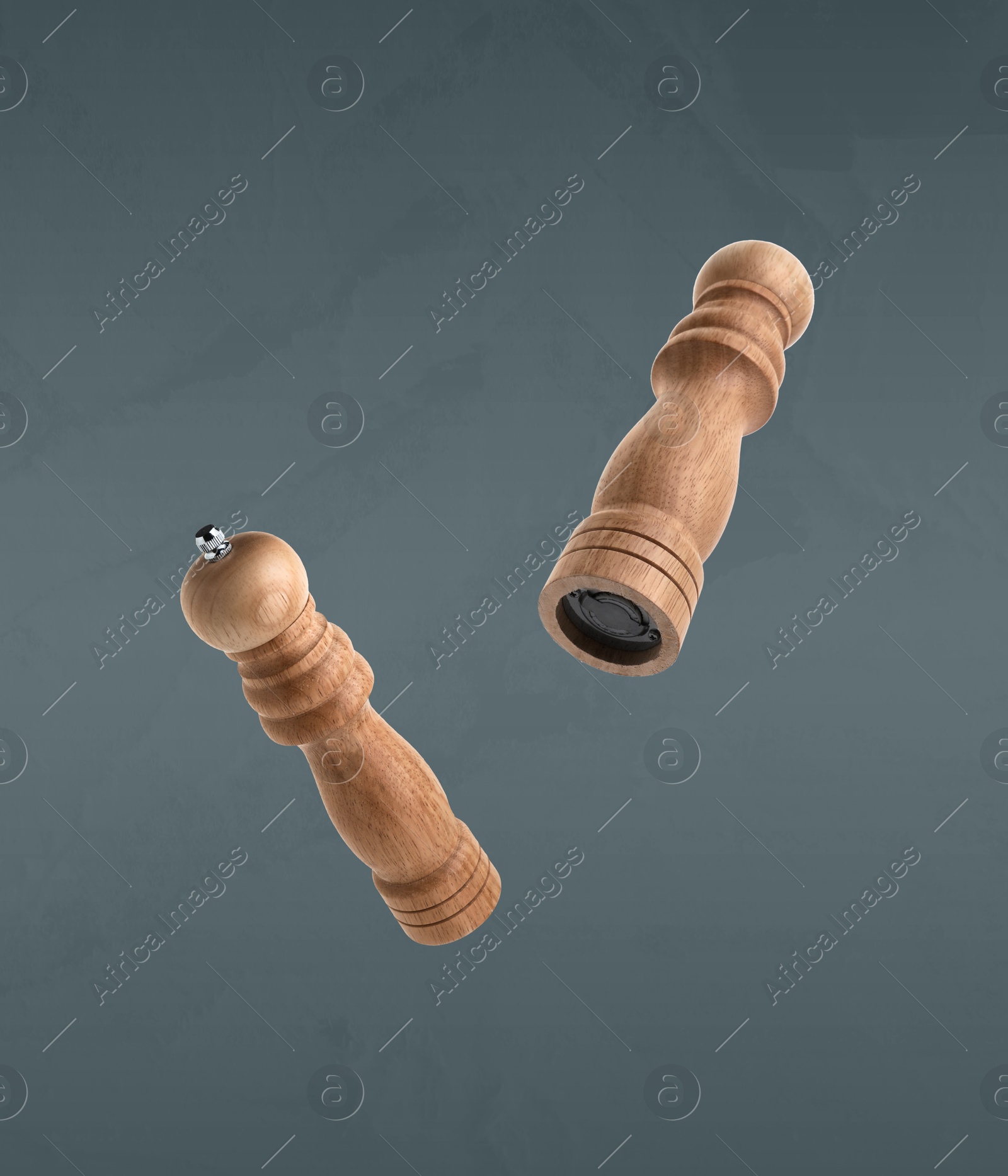 Image of Salt and pepper mills in air on grey background