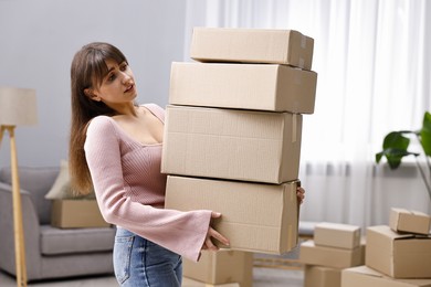 Moving day. Woman with cardboard boxes in her new home