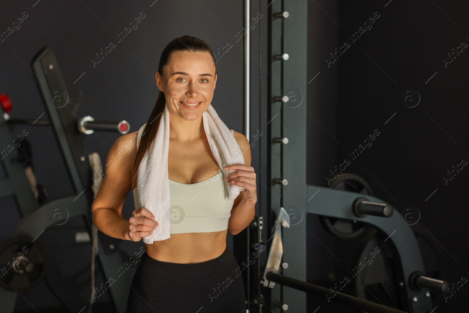 Photo of Happy woman with terry towel in gym. Space for text