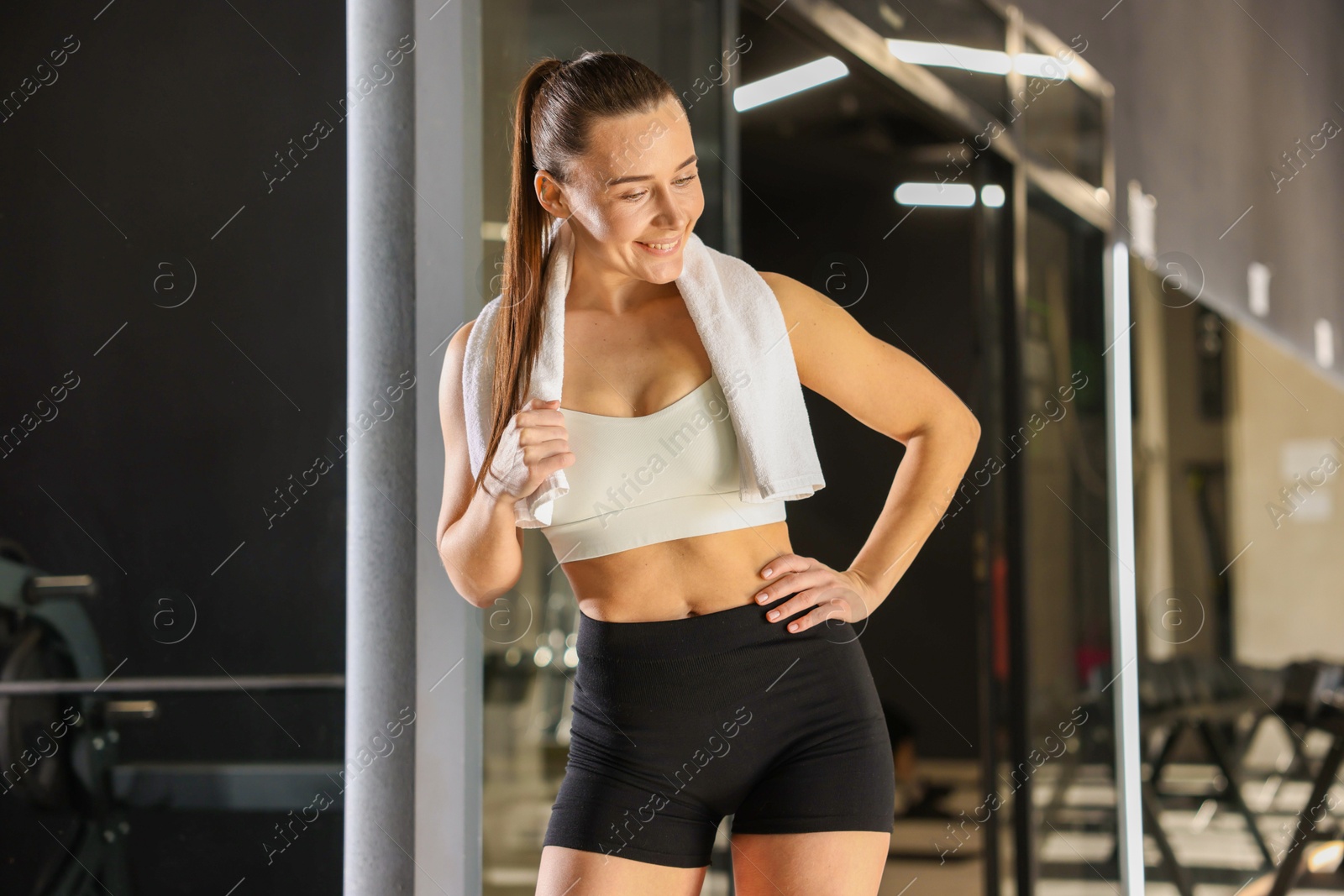 Photo of Happy woman with towel in fitness studio