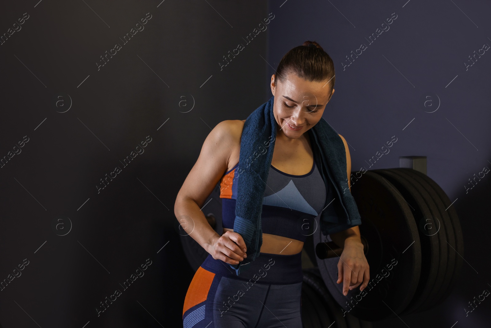 Photo of Happy woman with terry towel in gym