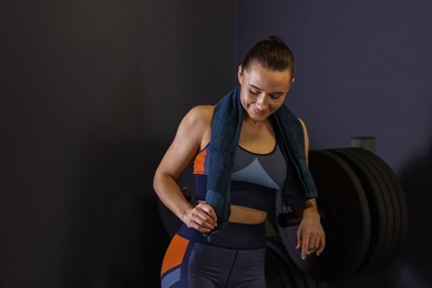 Happy woman with terry towel in gym