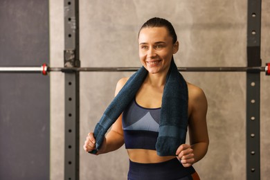 Happy woman with terry towel in gym