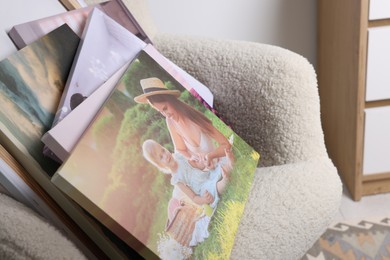 Canvas with different printed photos on armchair, closeup