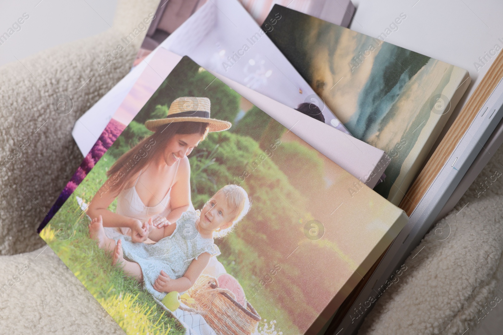 Photo of Canvas with different printed photos on armchair, closeup