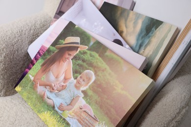 Photo of Canvas with different printed photos on armchair, closeup