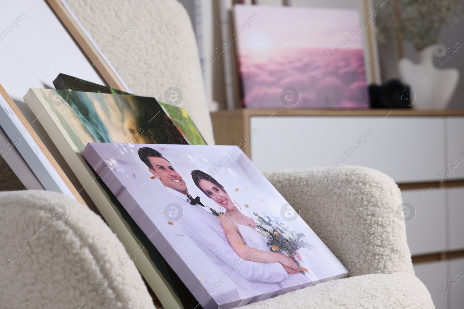 Photo of Canvas with different printed photos on armchair indoors, closeup