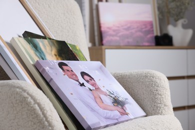 Canvas with different printed photos on armchair indoors, closeup