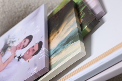 Photo of Canvas with different printed photos on light background, closeup