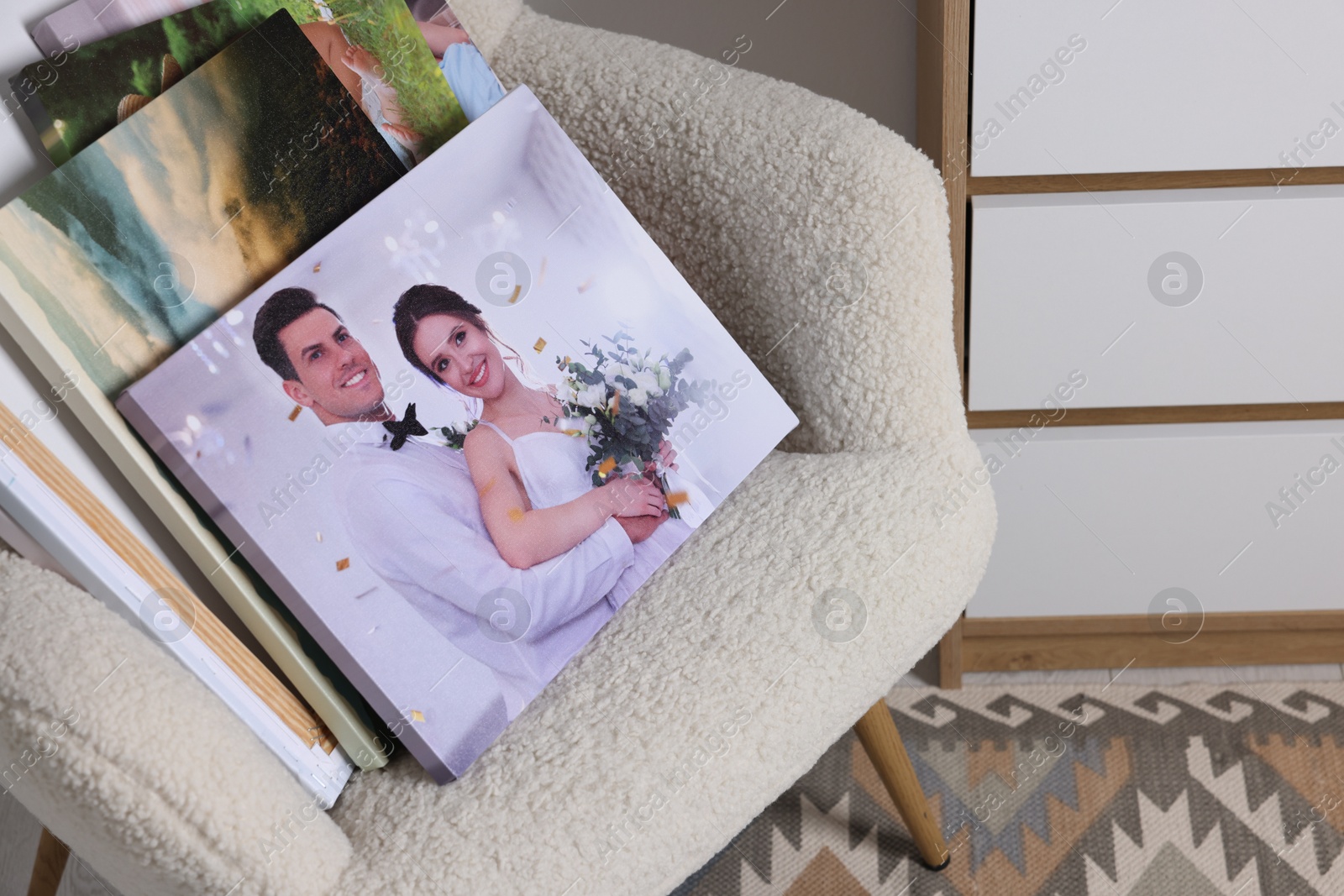 Photo of Canvas with different printed photos on armchair, closeup