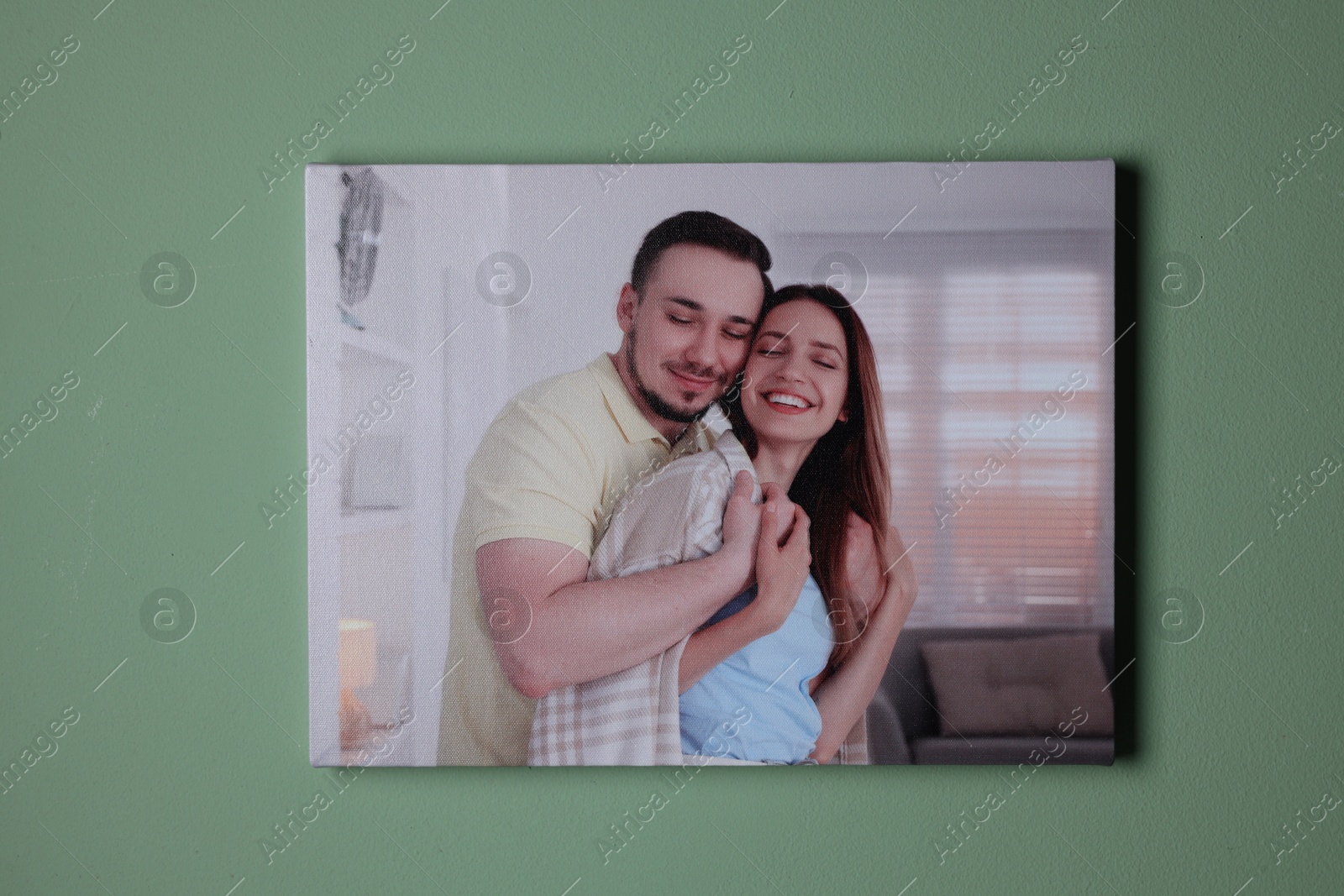 Photo of Canvas with printed photo of happy couple on green wall indoors