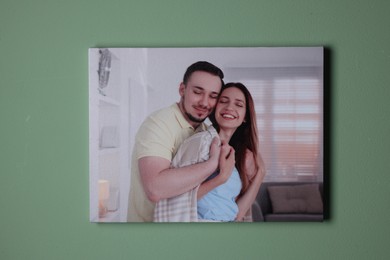 Photo of Canvas with printed photo of happy couple on green wall indoors