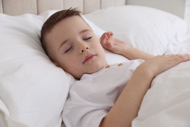 Photo of Bedtime. Cute boy sleeping in comfortable bed