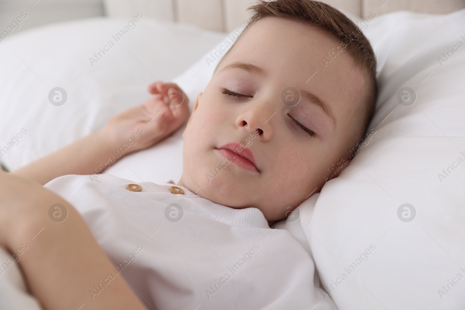 Photo of Bedtime. Cute boy sleeping in comfortable bed