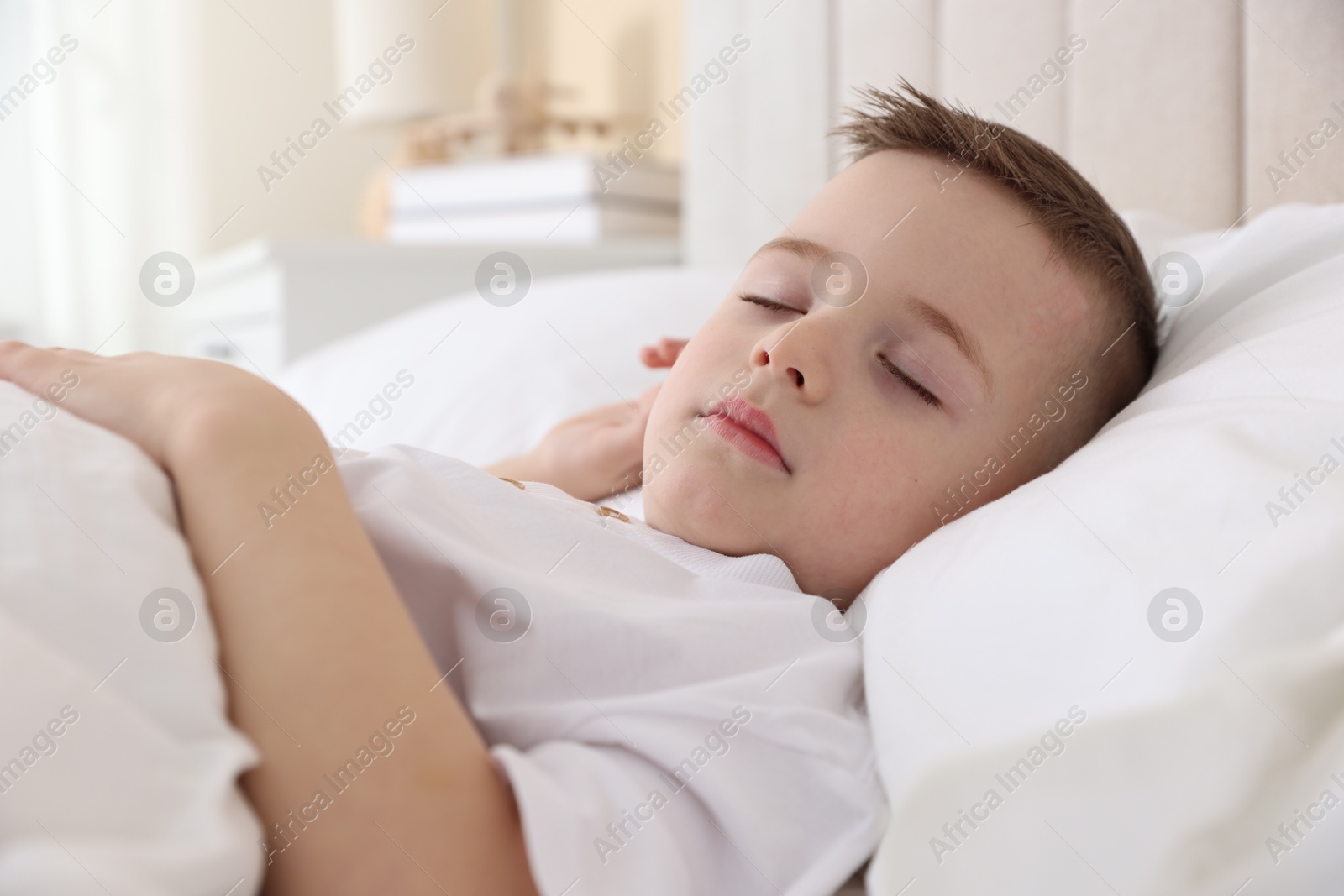 Photo of Bedtime. Cute boy sleeping in comfortable bed