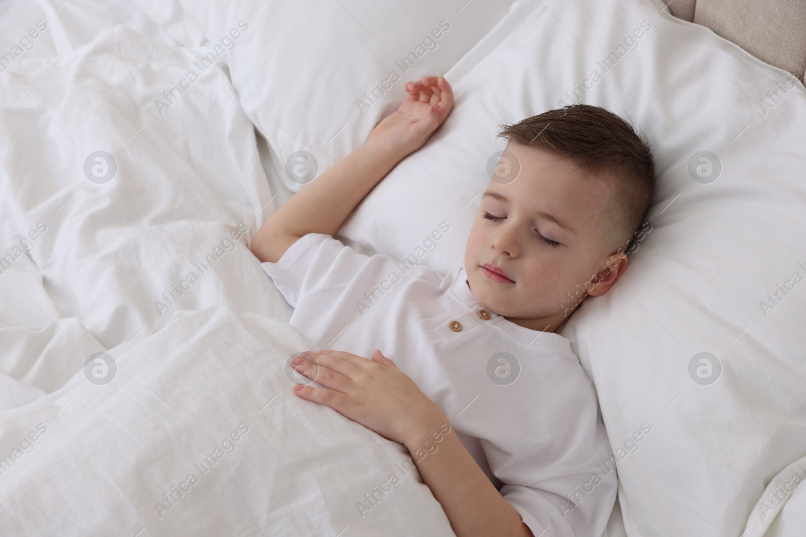 Photo of Bedtime. Cute boy sleeping in comfortable bed