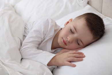 Photo of Bedtime. Cute boy sleeping in comfortable bed