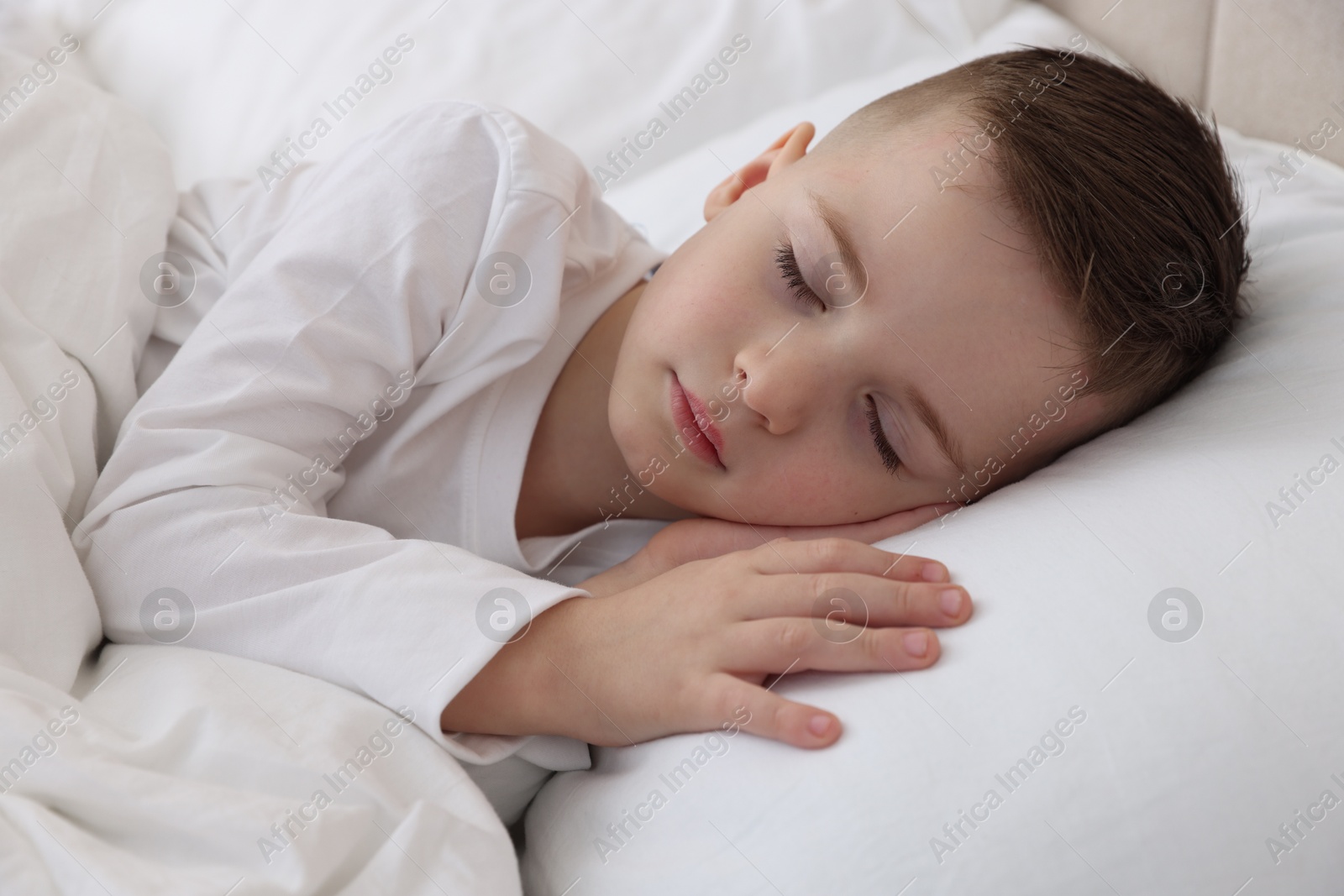 Photo of Bedtime. Cute boy sleeping in comfortable bed