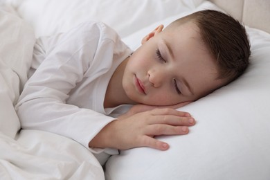 Photo of Bedtime. Cute boy sleeping in comfortable bed