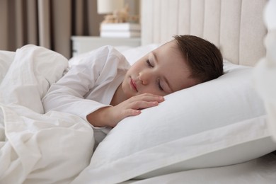 Photo of Bedtime. Cute boy sleeping in comfortable bed