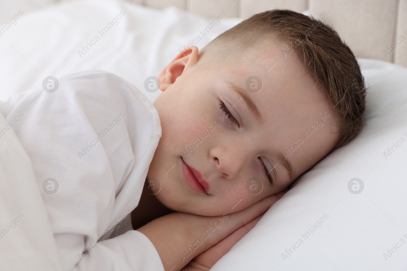 Photo of Bedtime. Cute boy sleeping in comfortable bed