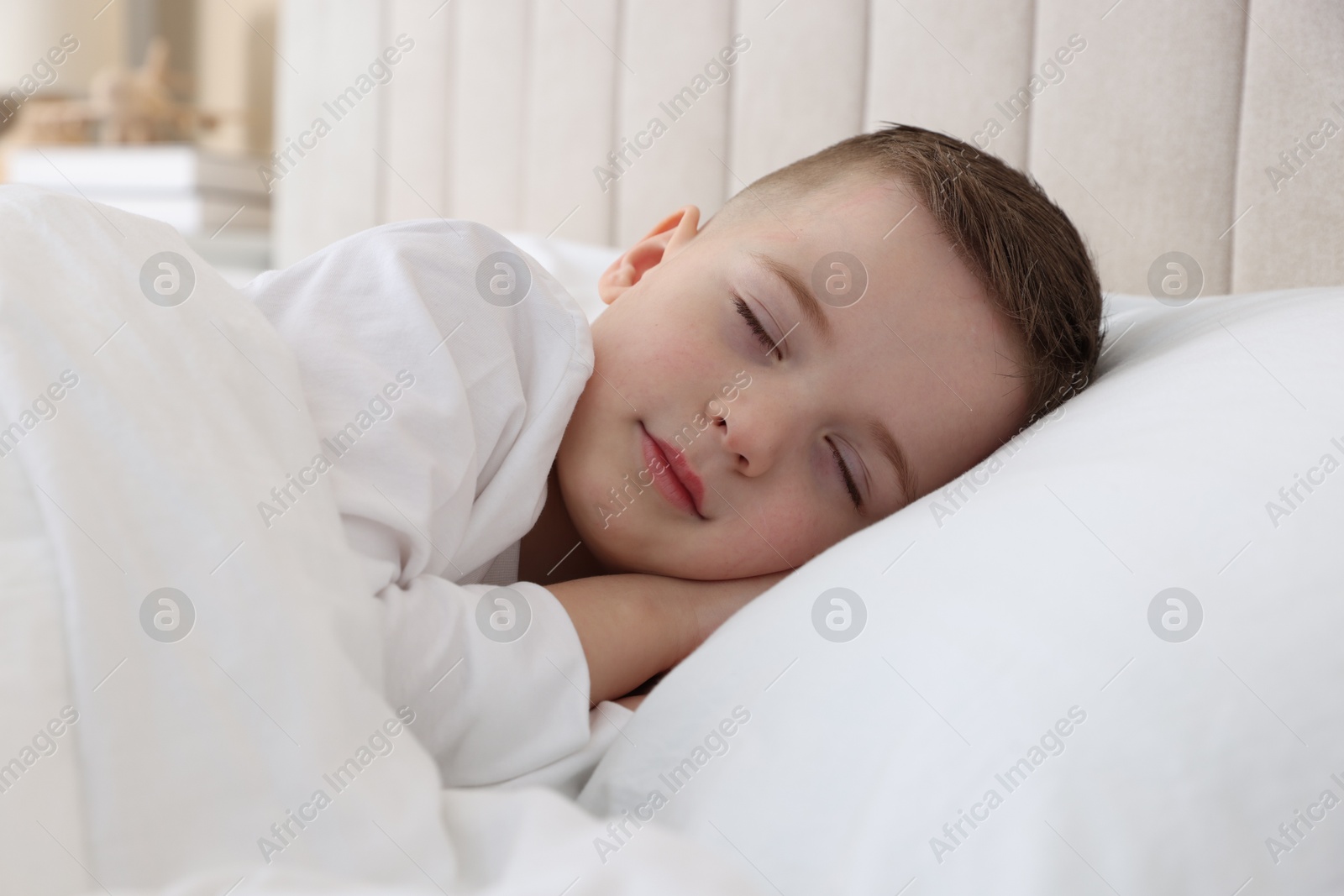 Photo of Bedtime. Cute boy sleeping in comfortable bed