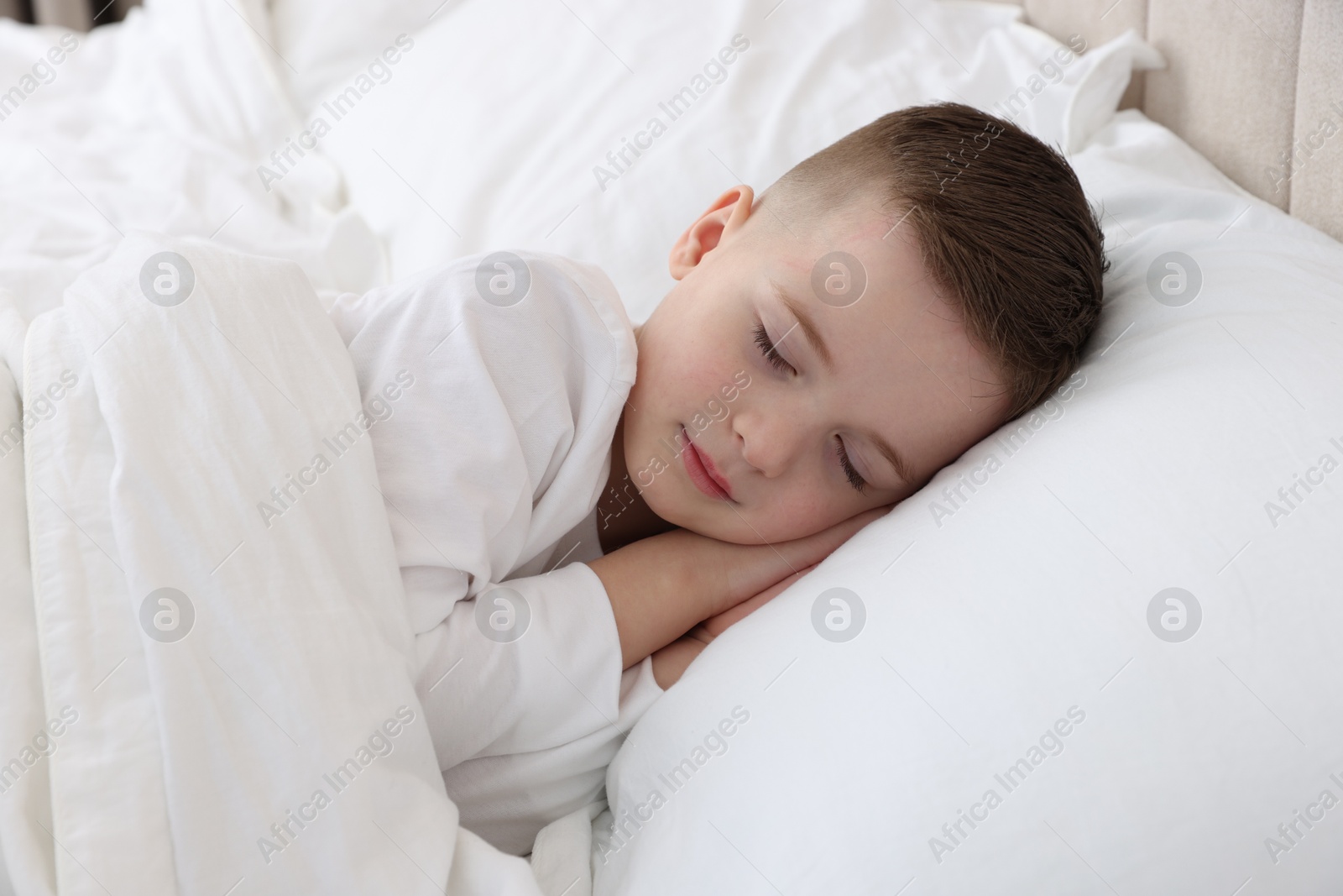 Photo of Bedtime. Cute boy sleeping in comfortable bed