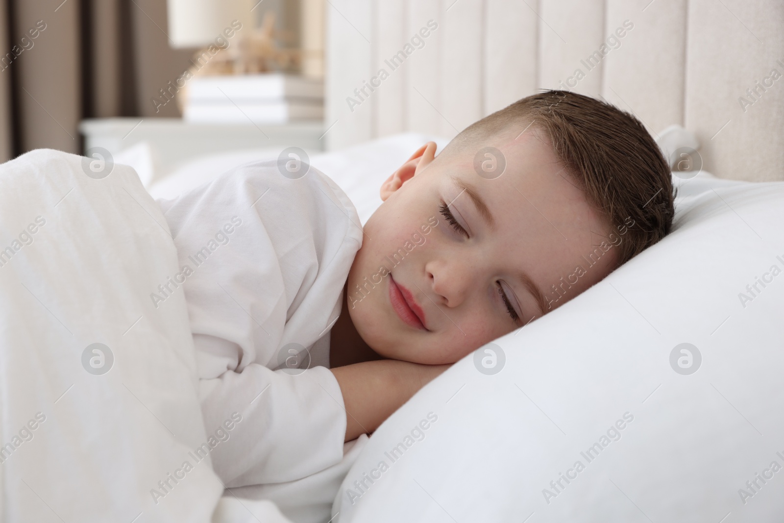 Photo of Bedtime. Cute boy sleeping in comfortable bed