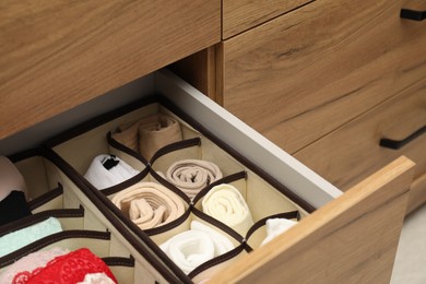 Photo of Organizers with different socks and bras in drawer, closeup