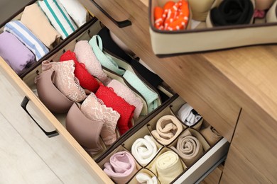 Photo of Organizers with folded clothes in drawer indoors, above view