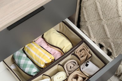 Photo of Organizers with folded clothes in drawer indoors, above view