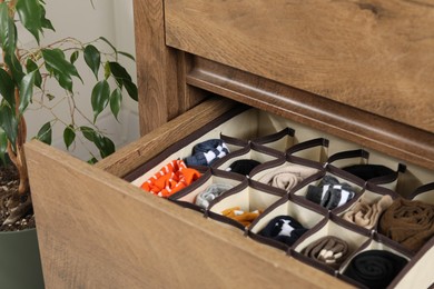 Organizer with different socks in drawer indoors, closeup