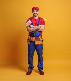 Photo of Professional painter with tools on orange background